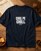 Navy blue t-shirt with 'Chai Pe Chill' text on a wooden table with snacks and a newspaper.